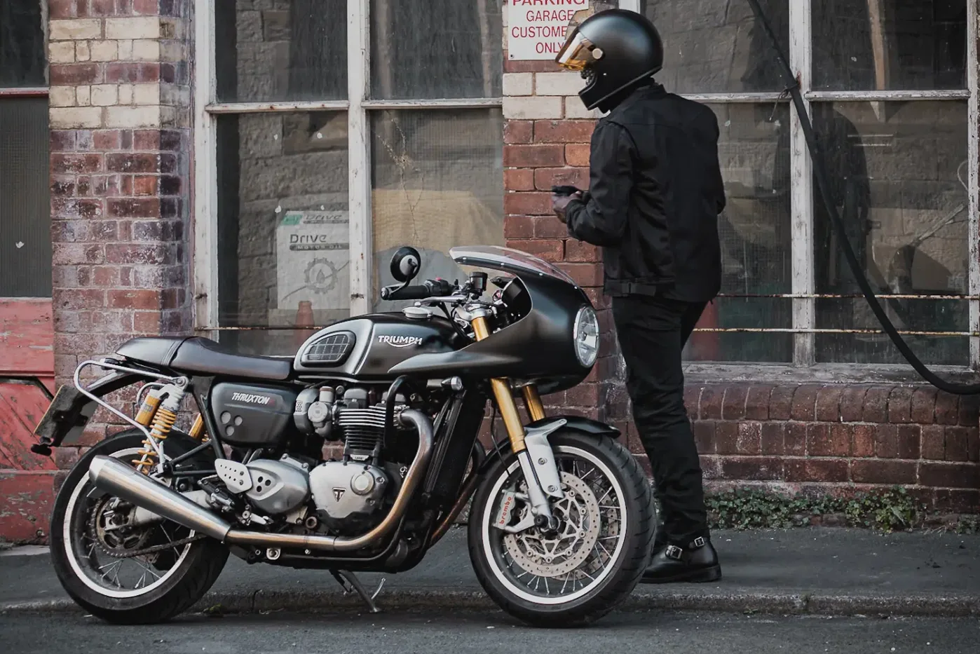 Rider wearing Pando Moto Air Tate Jacket walking towards a Thruxton 1200 R