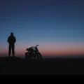 Rider standing next to an AOTOS Flux 26 in the desert at dusk