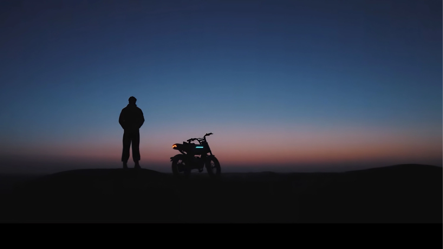 The Demise of the Pedelec? Why AOTOS is Betting Big on its 'Human Mobility Robot' 1 Rider standing next to an AOTOS Flux 26 in the desert at dusk